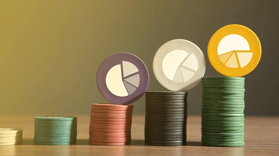 Stacks of colored tokens with pie chart symbols on top of each stack
